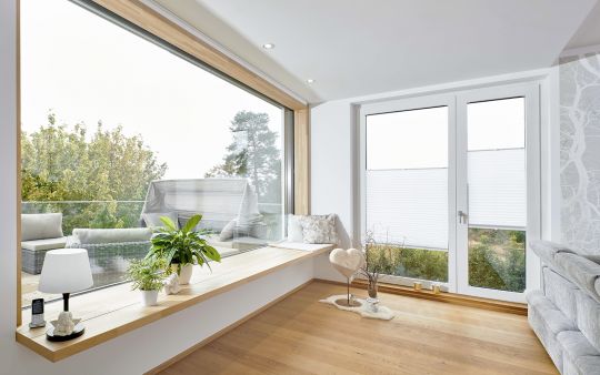 Wohnbereich mit großem Holzfenster Fenstern und Balkontür aus Holz