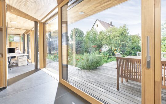 Innenansicht Bürogebäude mit eingeschossiger UNILUX FineLine Pfosten-Riegel-Fassade und Hebe-Schiebe-Element aus Holz und Alu