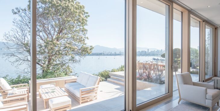 Blick auf Terrasse am See durch geöffnete UNILUX Holz-Alu Hebe-Schiebeanlage