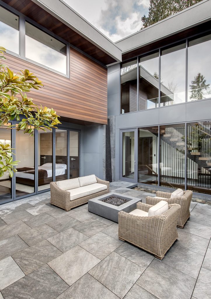 Terrasse vor modernem Wohngebäude mit UNILUX FineLine Pfosten-Riegel-Fassade aus Holz und Alu